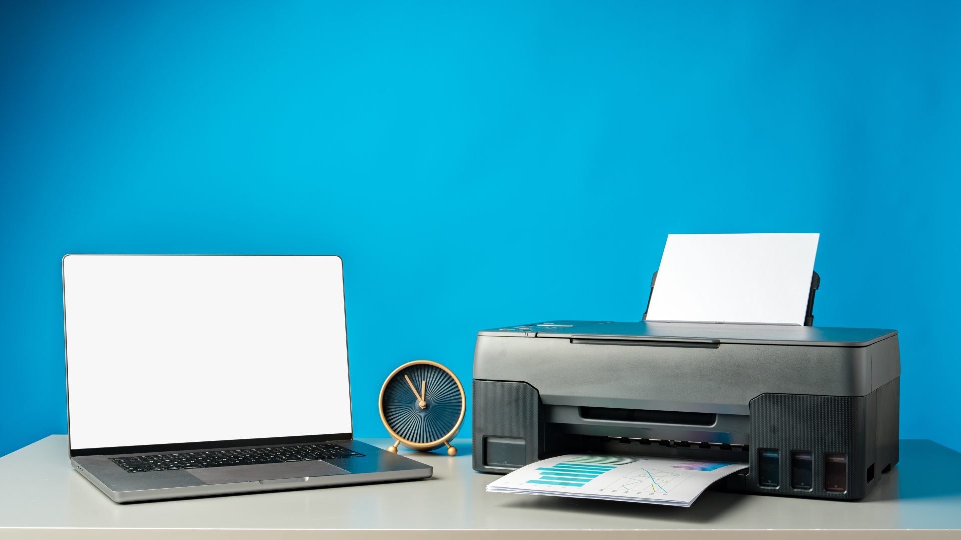 Laptop e impresora moderna sobre fondo cyan corporativo