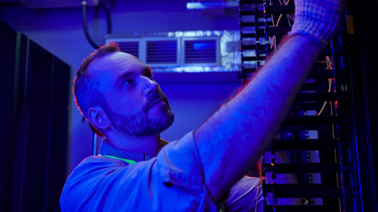 Técnico profesional inspeccionando equipo de red en centro de datos