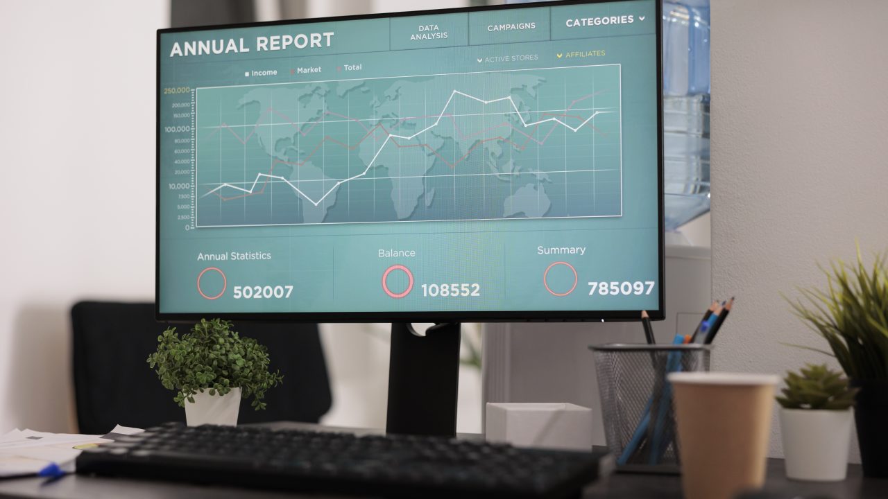 Monitor profesional con software de análisis de negocio sobre escritorio corporativo